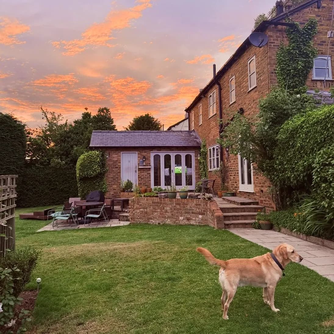 Oak Tree Cottage at dusk, with Corey on the lawn